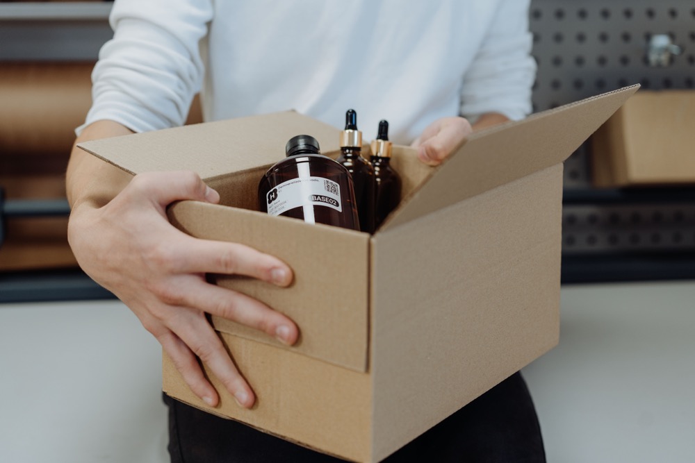 Packing an order — raw materials in small bottles in a cardboard box